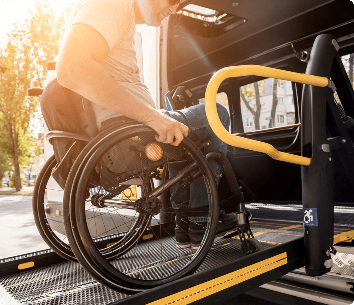 Person using wheelchair lift into vehicle.